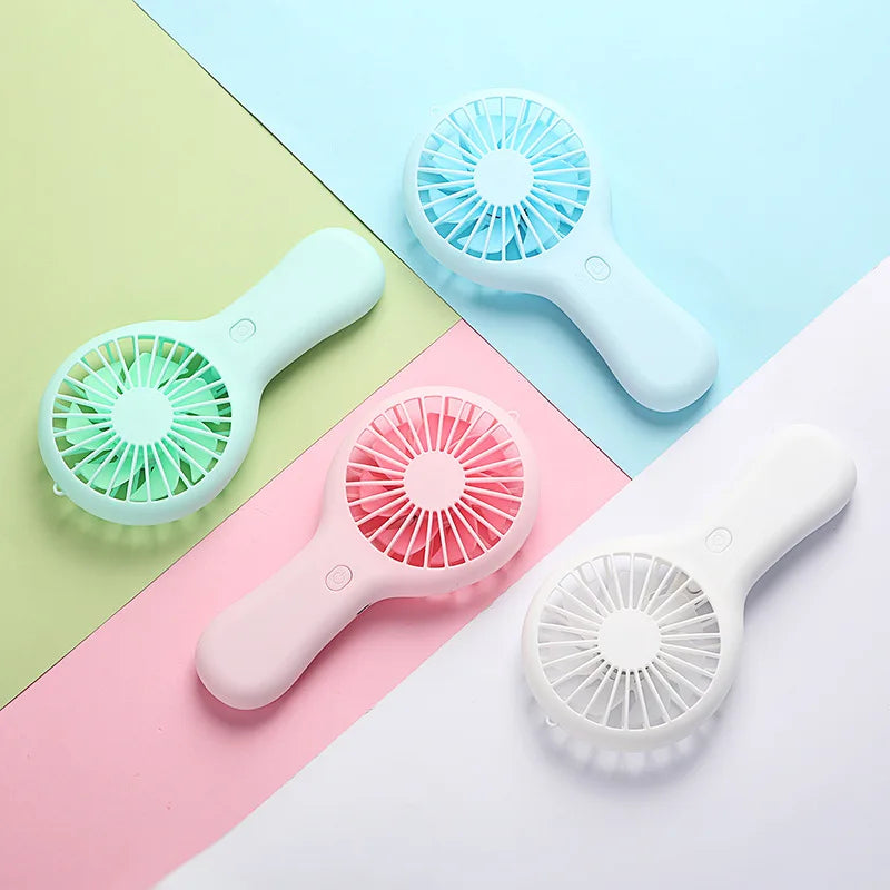 Set of four portable handheld mini fans in pastel green, blue, pink, and white, ideal for travel, desk, or outdoor cooling